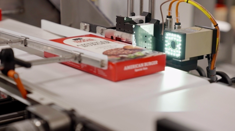 Integrated marking and verification system for end-of-line food packaging